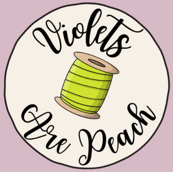 Circular logo with a green spool of thread and 'Violets Are Peach' text on a light purple background